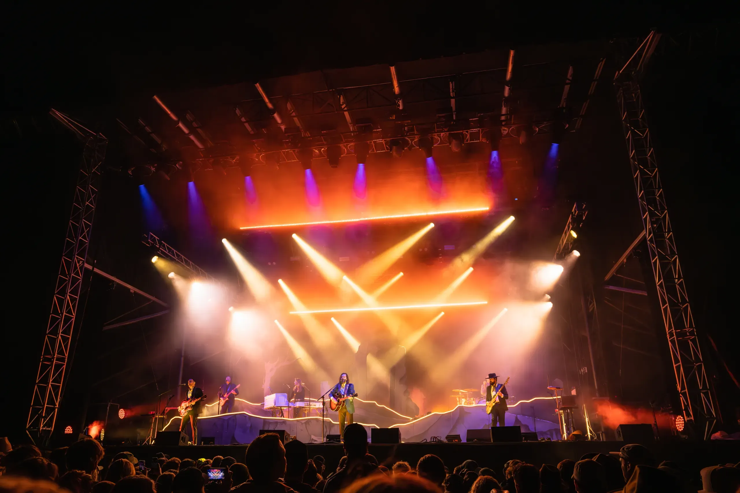 Lord Huron performing beneath orange stage lights at Wildlands in 2023.