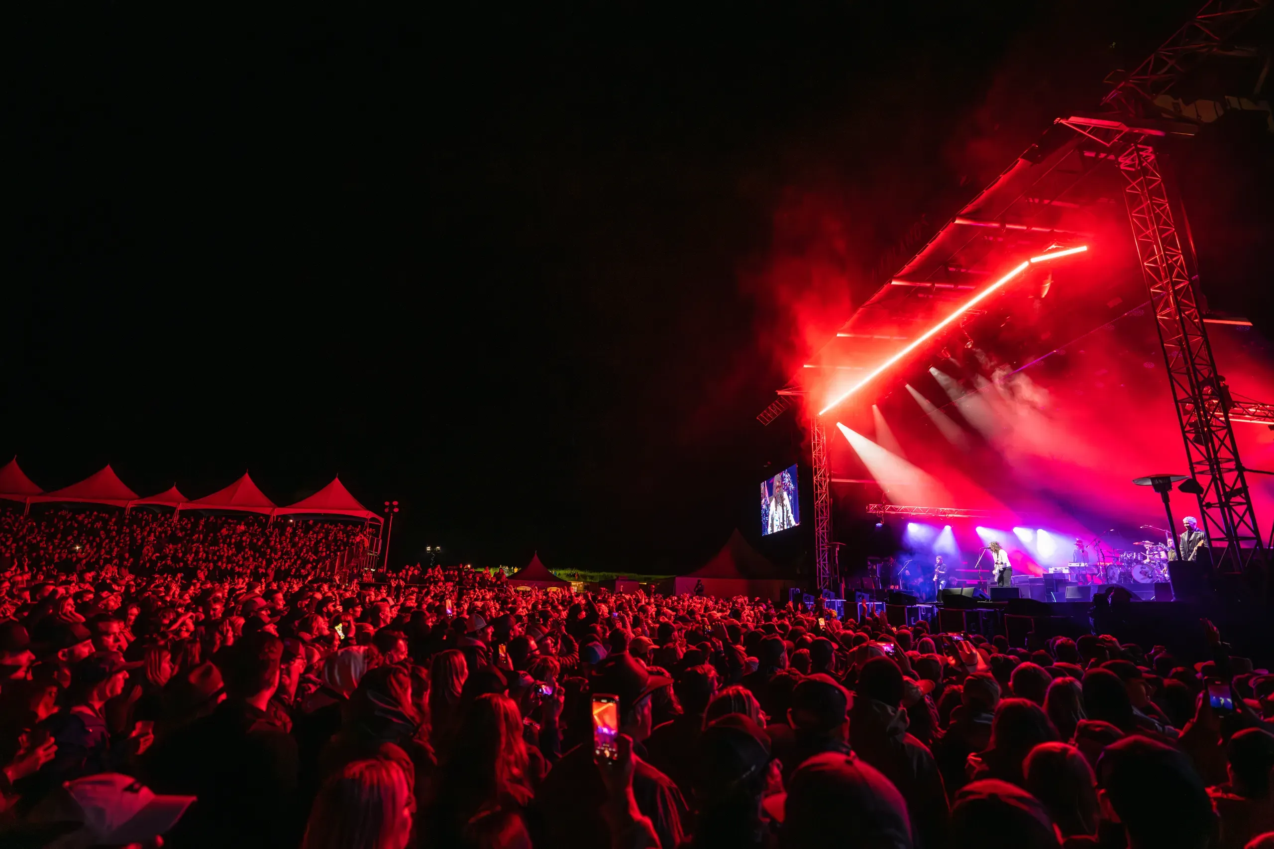 Foo Fighters performing for the Wildlands crowd under red lights in 2023.