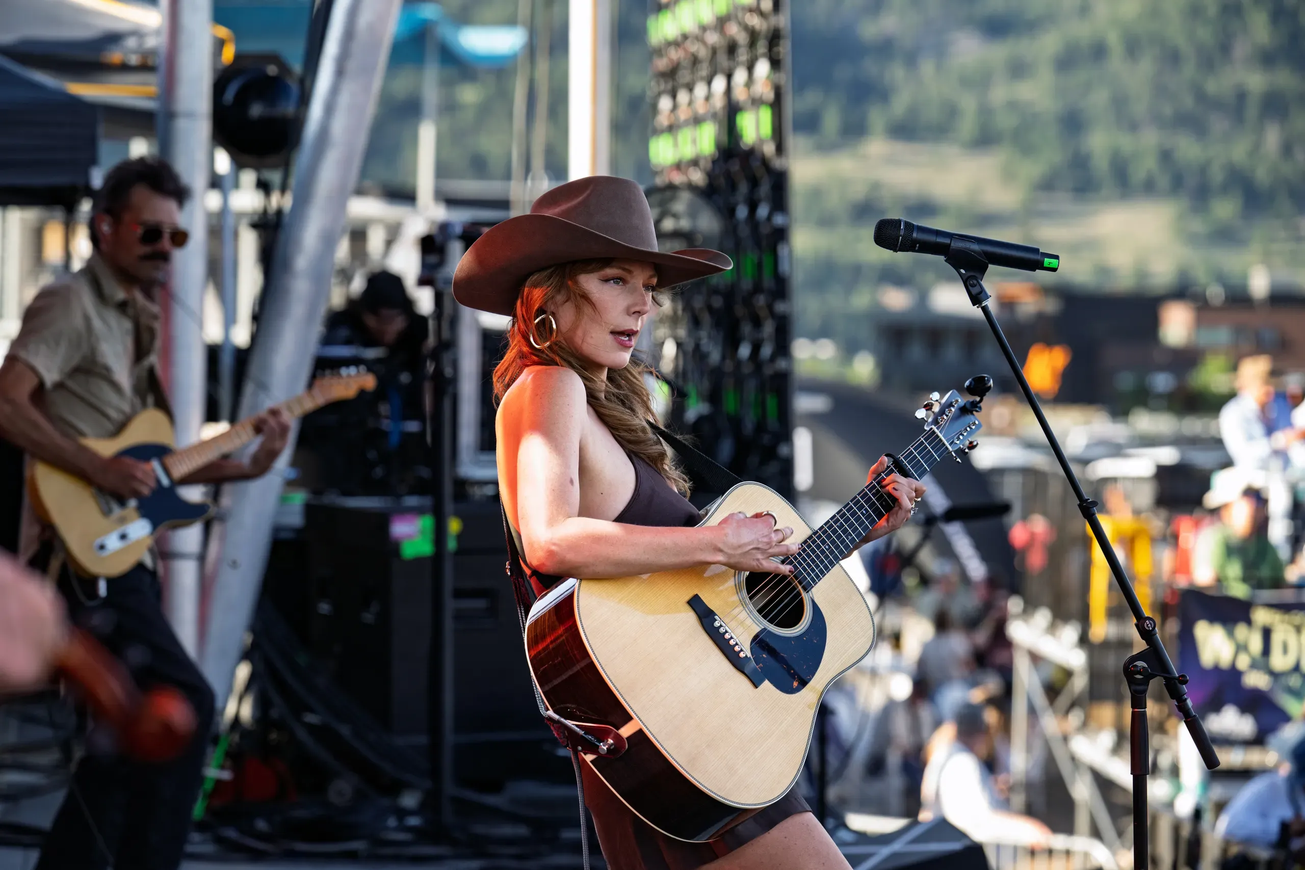 A guitarist mid-set on the main stage with the lighting rig behind her.
