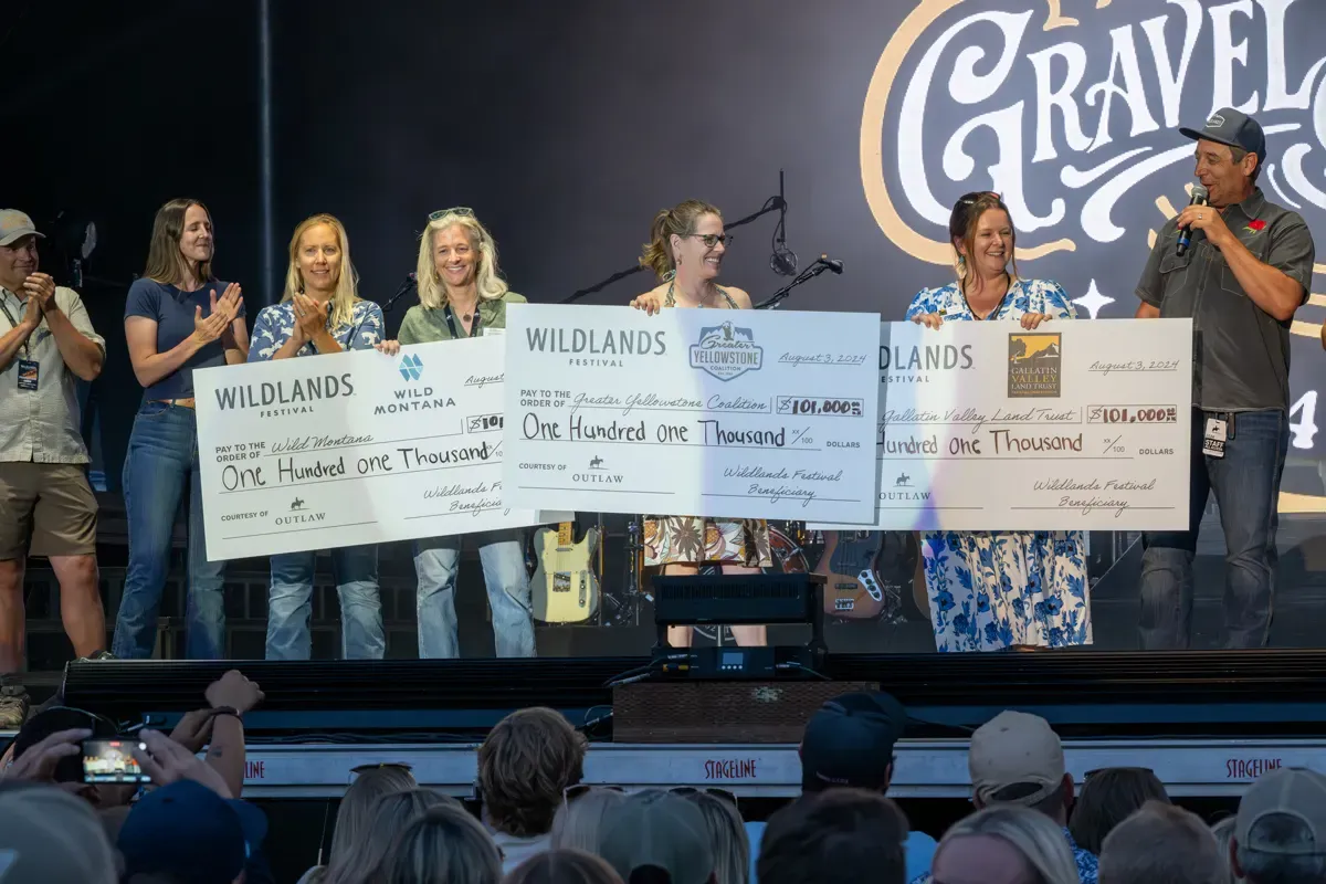 Conservation partners on the Wildlands stage holding checks for Wild Montana, Greater Yellowstone Coalition and Gallatin Valley Land Trust in 2024.