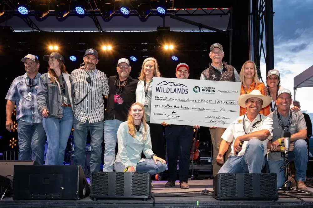 A group onstage holding an oversized Wildlands conservation donation check.