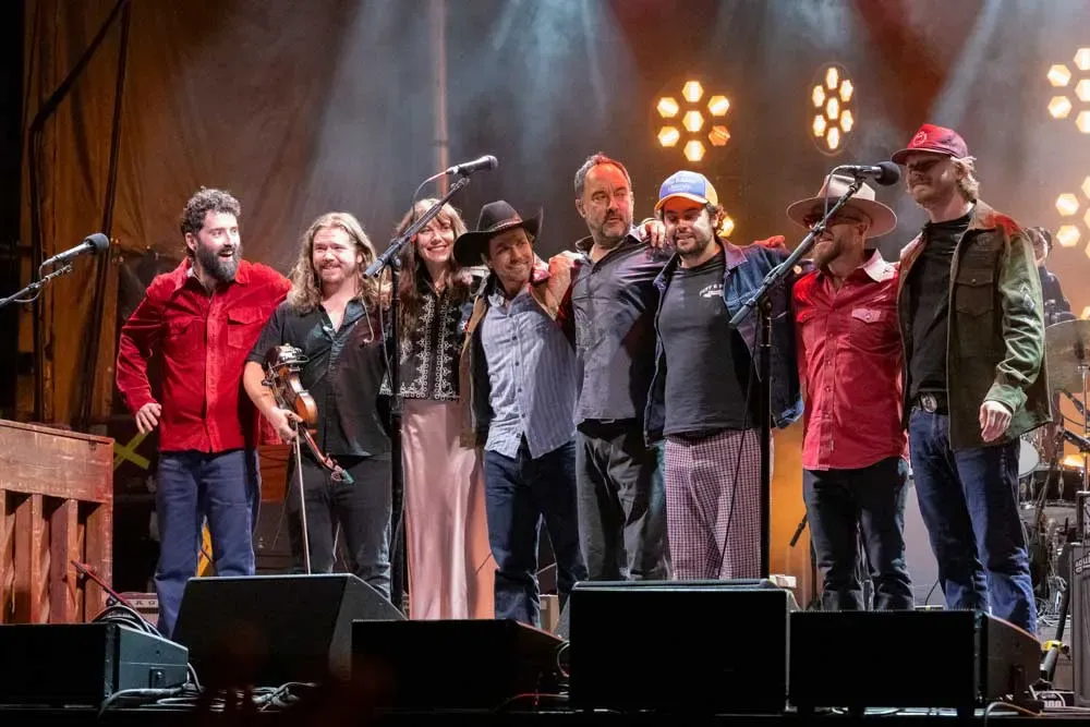 Musicians standing together at the front of the stage after a performance.