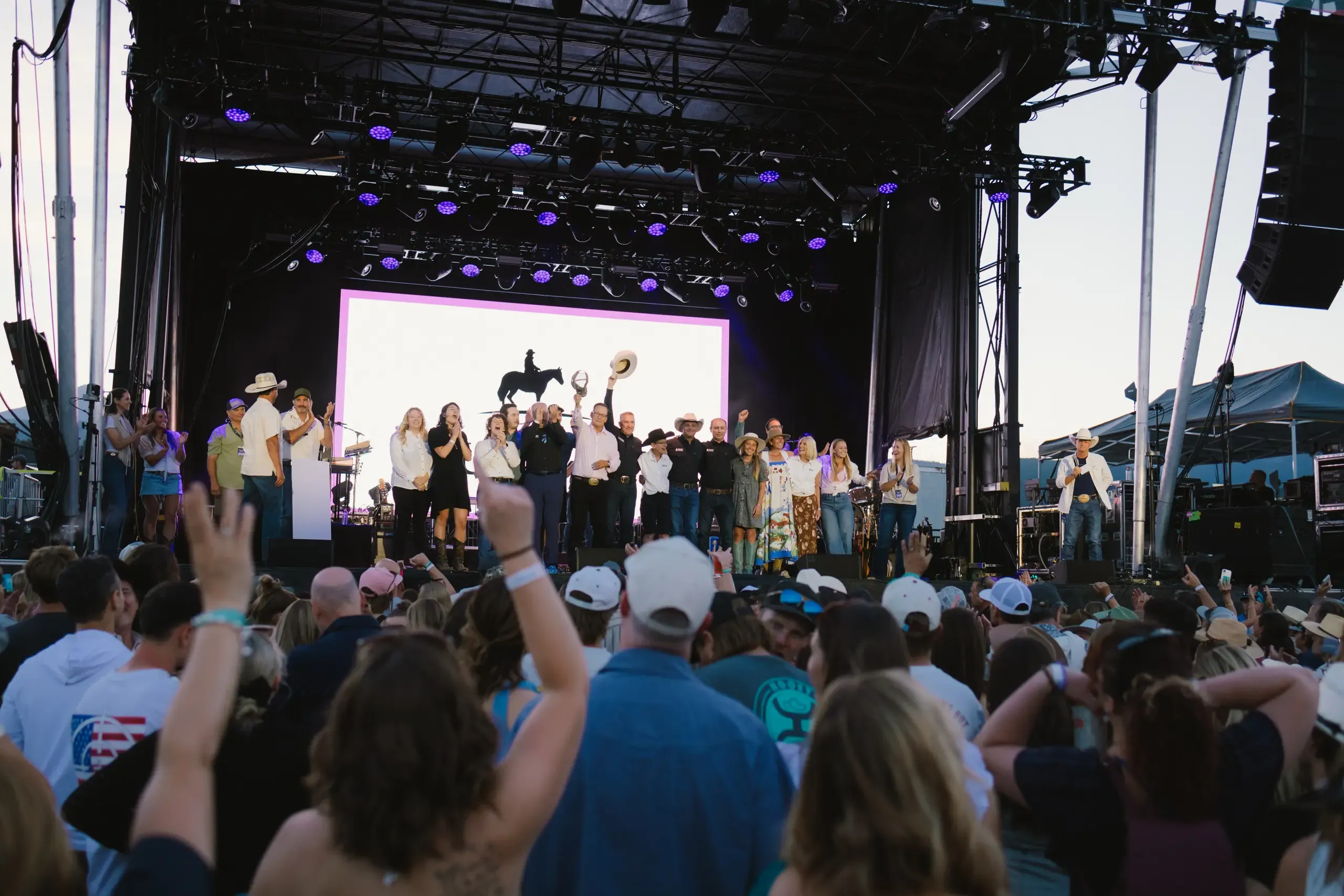 A group onstage during a presentation as the audience watches.